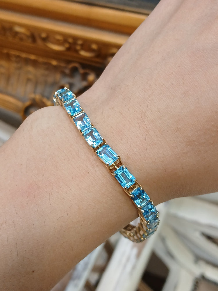 Women's 9ct Yellow Gold Tennis Bracelet with Emerald Cut Blue Topaz - Hyman’s Jewellers